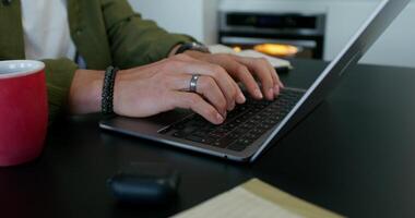 A man typing on a laptop keyboard sitting at his desk at home. Close-up of his hands, an unrecognizable person. Daylight - keyboard photo