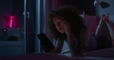 A man uses a mobile phone lying on the bed. Dark room, home interior - mobile - a photo