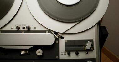 Sound recording on a tape recorder in a recording studio. Fast movement of the magnetic tape, close-up - recorder photo
