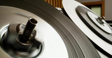 Sound recording on a tape recorder in a recording studio. Fast movement of the magnetic tape, close-up - recording photo