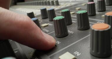A man controls a mixing console while recording audio in the studio. Close-up of his hand, an unrecognizable person photo