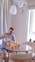 A couple enjoying a romantic breakfast with croissants and coffee, sharing a fun conversation at home. Concept. home cooking, relationship blogs, culinary experiences. video