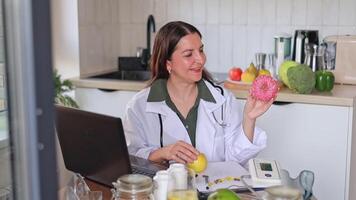 Close-up of a nutritionist at a table with fruits and vegetables. Consultation on proper nutrition using a donut as an example of unhealthy food. video