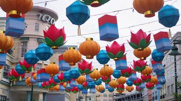 a street with many colorful paper lanterns hanging from the street photo