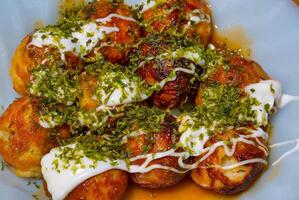 Takoyaki with sauces and garnish photo