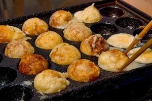 cooking takoyaki in street photo