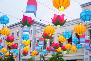 a street with lots of colorful paper lanterns hanging from the street photo
