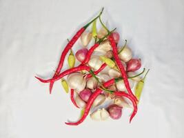 Garlic, shallots and fresh chilies arranged on a white background photo