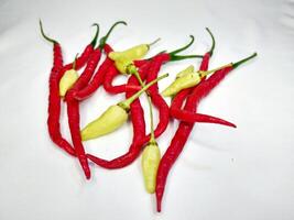 Red chili and fresh cayenne pepper piled up with a white background photo