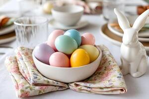 Festive Easter table setting with pastel eggs ceramic bunny and floral napkins in bright daylight photo