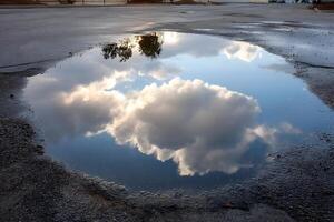 Puddle Reflects Cloudy Sky photo