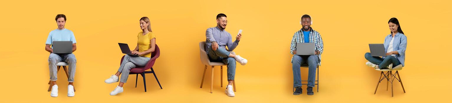 A group of five individuals engages with laptops and mobile devices, showcasing a blend of focused work and casual interaction. The colorful yellow backdrop adds energy to the setting. photo
