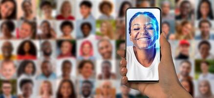 A person holds a smartphone with a face scan, surrounded by a collage of diverse portraits, emphasizing modern identification technology. photo