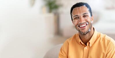 A smiling man with facial recognition technology applied, showcasing how modern systems check identification efficiently. This reflects the growing trend of tech use in daily activities. photo
