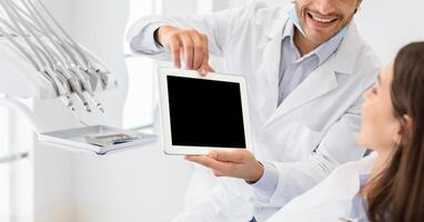 Cropped image of dentist showing patient blank digital tablet screen, dental clinic, panorama photo