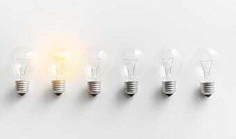 Concept for creativity, innovation and solution. Illuminated light bulb in row of dim ones on white background photo