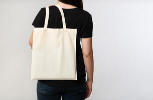 Say No To Plastic. Unrecognizable Brunette Girl Holding Eco Bag On White Studio Background. Back View, Cropped, Free Space photo