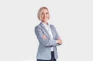 Beautiful smiling businesswoman with crossed arms on grey background photo