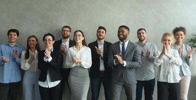 Group of business people clapping hands to congratulate boss, standing ovation after successful meeting photo