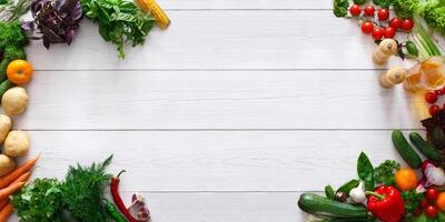 Raw food diet banner. Frame of fresh organic vegetables with spices and oil on white wooden background, panorama with empty space photo