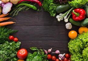 Frame of fresh organic vegetables on rustic wood background. Healthy natural food on table with copy space. Cooking ingredients top view, mockup for recipe or menu photo