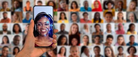 A person holds a smartphone displaying a face recognition scan. The background is a collage of diverse faces. This modern technology showcases identification methods and security features. photo