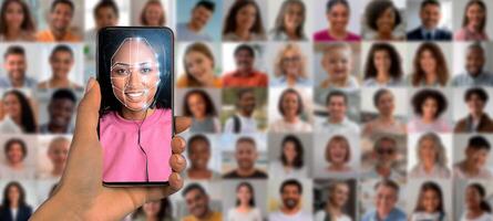 A hand holds a smartphone showcasing facial recognition technology with a smiling person on the screen. photo
