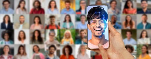 A smartphone screen shows a smiling face being scanned for identification, surrounded by a collage of diverse people in the background. This signifies advances in technology and identity recognition. photo