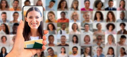 A person holds a smartphone displaying a facial recognition scan. The screen shows a smiling individual with a collage of faces behind, showcasing advancements in identification technology. photo