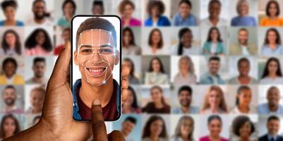 A person uses a smartphone to scan their face for identification. The screen displays a facial recognition overlay, highlighting the subject among a collage of diverse faces in the background. photo