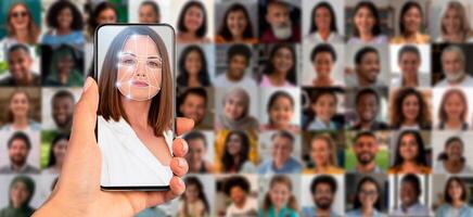 A hand holds a smartphone showing a facial scan. In the background, a collage of diverse faces highlights the use of modern technology for identification and recognition in everyday life. photo
