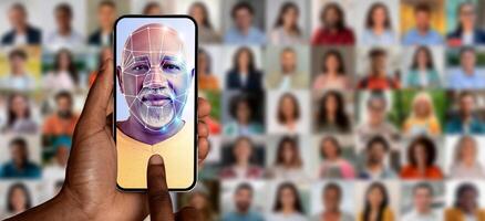 A person scans their face with a smartphone while surrounded by a collage of portraits. This modern technology highlights face identification, showcasing its capabilities in a connected world. photo