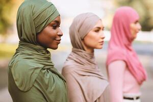 Three Diverse Muslim Women Posing Standing In Line And Looking Aside Outdoor, Wearing Traditional Hijab Headscarf. Selective Focus. Equality And Togetherness, Diversity Of Islamic Females photo