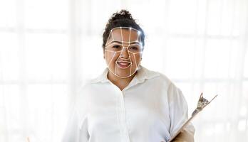 A woman smiles while displaying facial recognition software on her face, highlighting modern technology's role in identification. This reflects the evolving nature of security in everyday life. photo