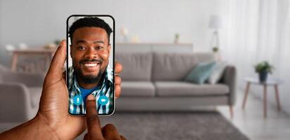 A person is enjoying a call from their home, connect with smiling man on the screen of their smartphone, showcasing the ease of modern communication. photo