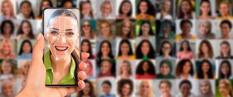 A person holds a smartphone displaying a facial scan of a smiling individual, surrounded by a collage of diverse faces in a vibrant, tech-focused atmosphere. photo