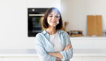 A woman stands confidently in a bright kitchen while a digital overlay showcases facial recognition technology. This reflects the integration of modern tech in daily life for identification purposes. photo