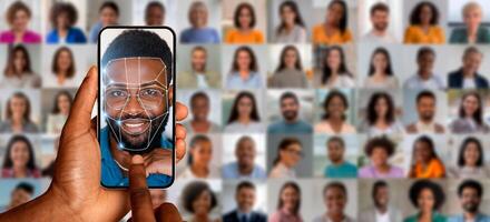 A person holds a smartphone in hand, using facial recognition technology to scan their face. photo