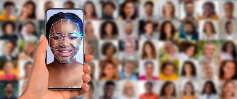 A person holds a smartphone displaying a face scan while surrounded by a collage of diverse portraits. This showcases the advancement of identification technology in daily life. photo