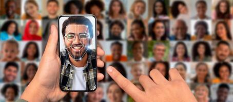 A person holds a smartphone displaying a facial recognition scan. Surrounding the individual are multiple portraits of diverse faces, showcasing advanced identification technology in everyday life. photo