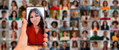 A person holds a smartphone up to their face, activating facial recognition technology. Behind them is a collage of diverse faces, showcasing modern identification methods in action. photo