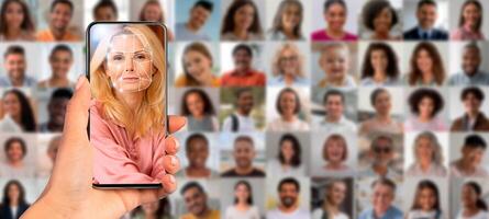 A hand holds a smartphone, showcasing a face scan on the screen. In the background, a collage of diverse faces highlights the theme of identification and technology in everyday life. photo