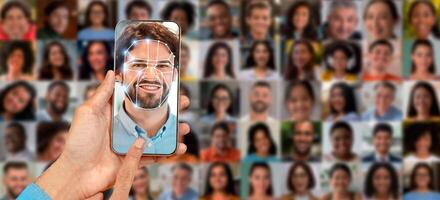 A person scans their face using a smartphone screen, showcasing advanced identification technology. The background features a collage of various faces, emphasizing modern identification systems. photo