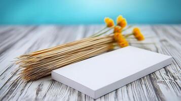 A minimalist arrangement featuring a blank notepad beside a bundle of yellow flowers on a wooden table photo