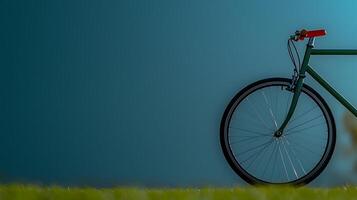 A minimalist bicycle resting against a smooth blue wall, surrounded by lush green grass photo