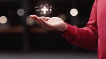 A person in a red shirt holds an open hand displaying glowing symbols representing health and wellness photo