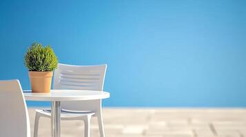A serene outdoor setting featuring a potted plant on a white table with empty chairs against a blue sky photo