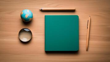 A serene workspace featuring a green notebook, globe, and magnifying glass on a wooden desk photo