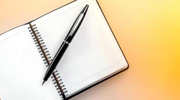 A sleek black pen resting on an open blank notebook with a warm gradient background photo