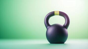 A sleek black kettlebell positioned on a smooth surface with a vibrant green gradient background photo